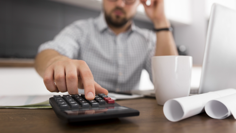 Pessoa analisando documentos financeiros e calculando dívidas sobre uma mesa, representando a renegociação de débitos e os direitos do consumidor.